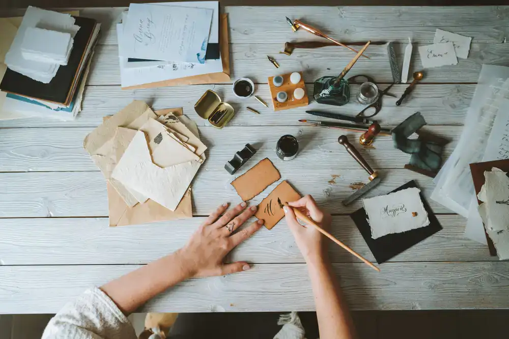 Artist carefully crafting hand-lettered envelopes in the studio